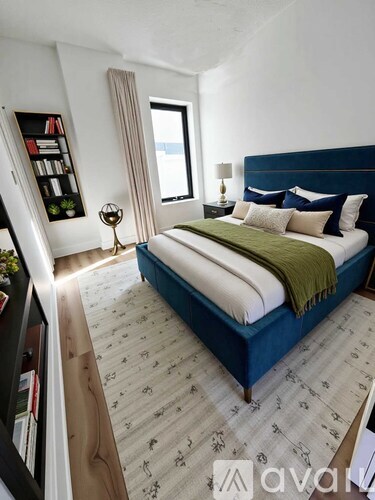 A bedroom with a large bed and a bookshelf.