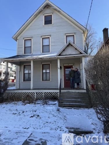 A house with a family standing on the porch.