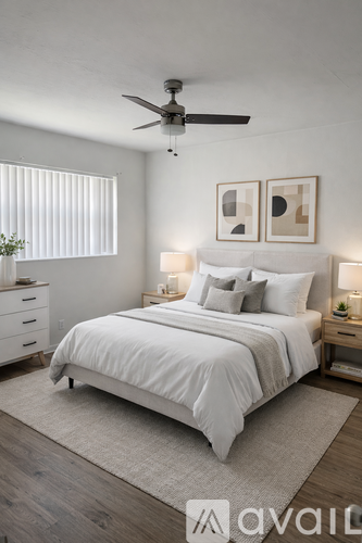A bedroom with a large bed, a ceiling fan, and two wall lamps.