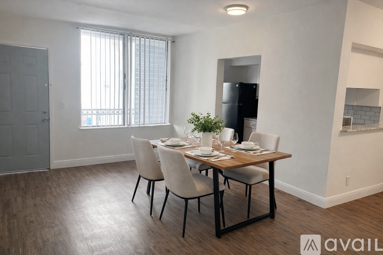 A dining room with a table set for two and a view of a city skyline.