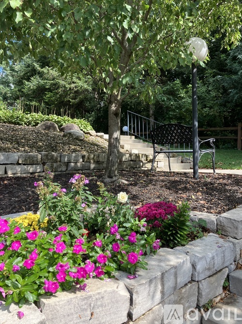 A garden with a stone wall and a tree.