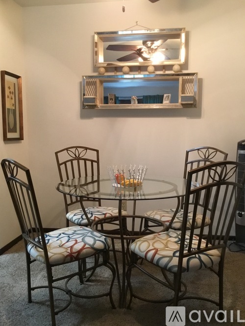 A glass table with four chairs around it.
