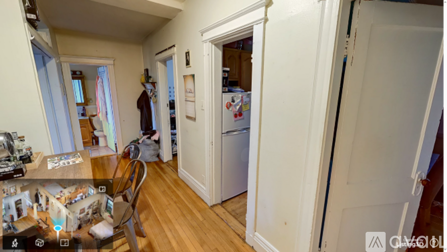 A kitchen with a refrigerator and a chair.