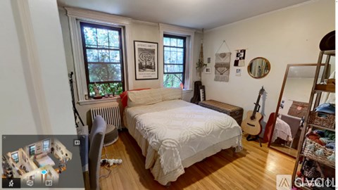 A bedroom with a bed, guitar, and window.