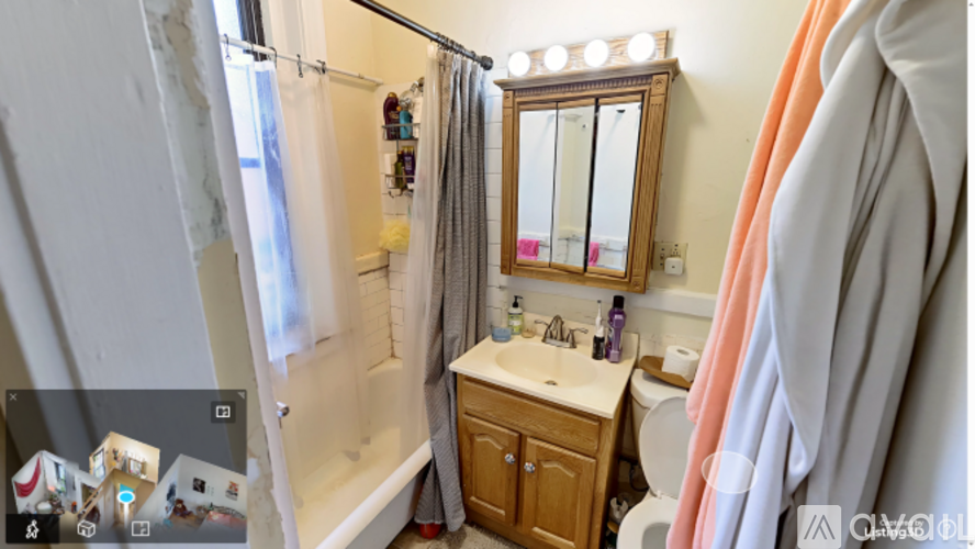 A bathroom with a sink, mirror, and shower.