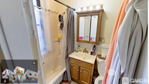 A bathroom with a sink, mirror, and shower.