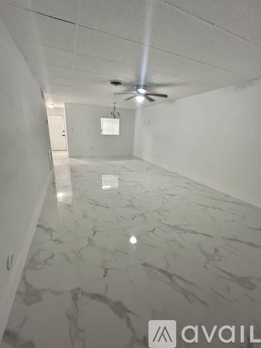 A room with a marble floor and a ceiling fan.