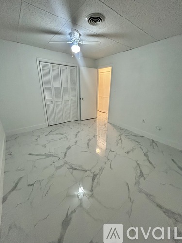 A room with a marble floor and a ceiling fan.