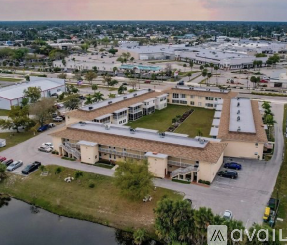 An aerial view of a building complex with a parking lot in front.