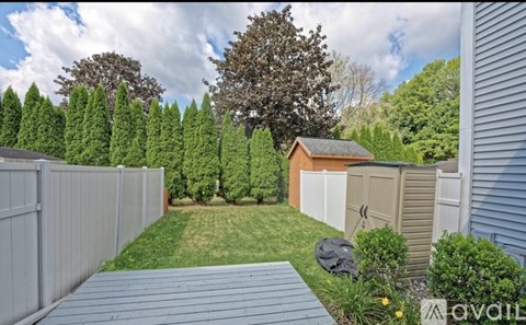 A backyard with a wooden deck and a shed.