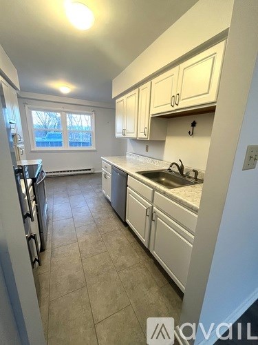 A kitchen with white cabinets and appliances.