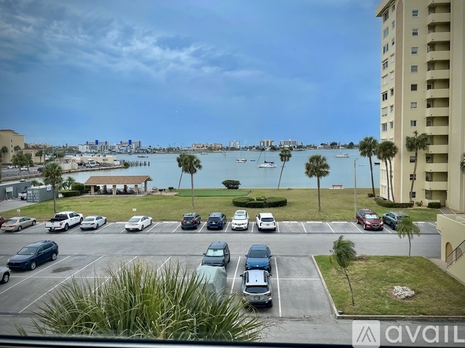 A parking lot with cars and a view of the water.