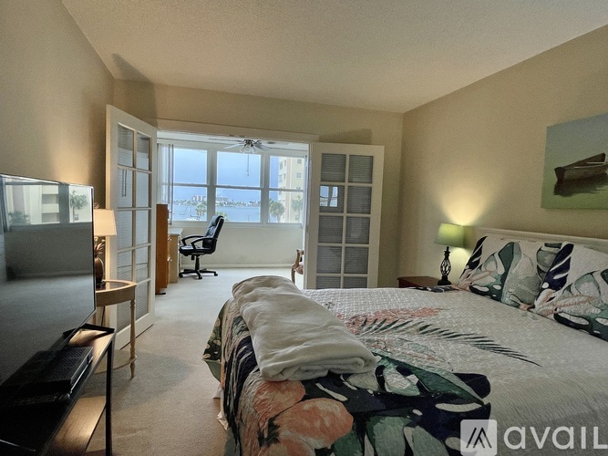 A bedroom with a large bed and a flat screen TV.