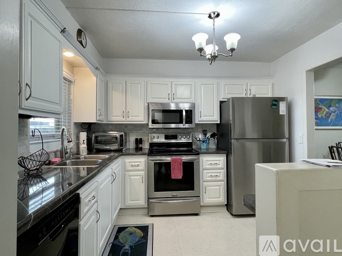 A kitchen with white cabinets and stainless steel appliances.