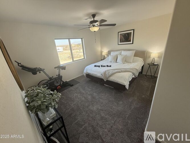 A bedroom with a large bed and a ceiling fan.