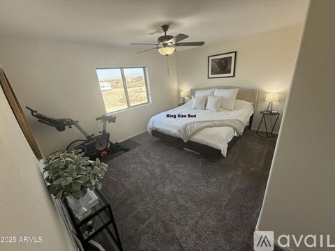 A bedroom with a large bed and a ceiling fan.