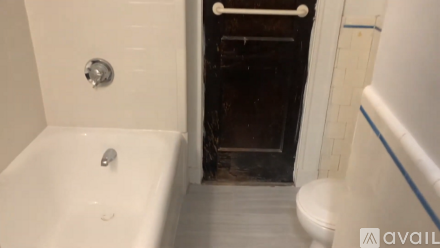 A bathroom with a white tub and a toilet.