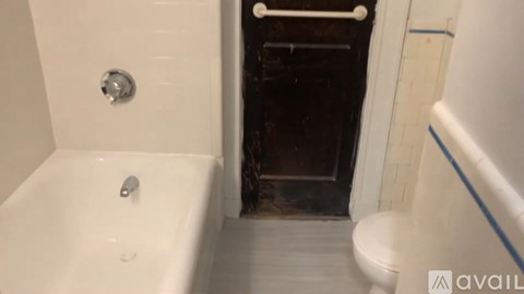 A bathroom with a white tub and a toilet.
