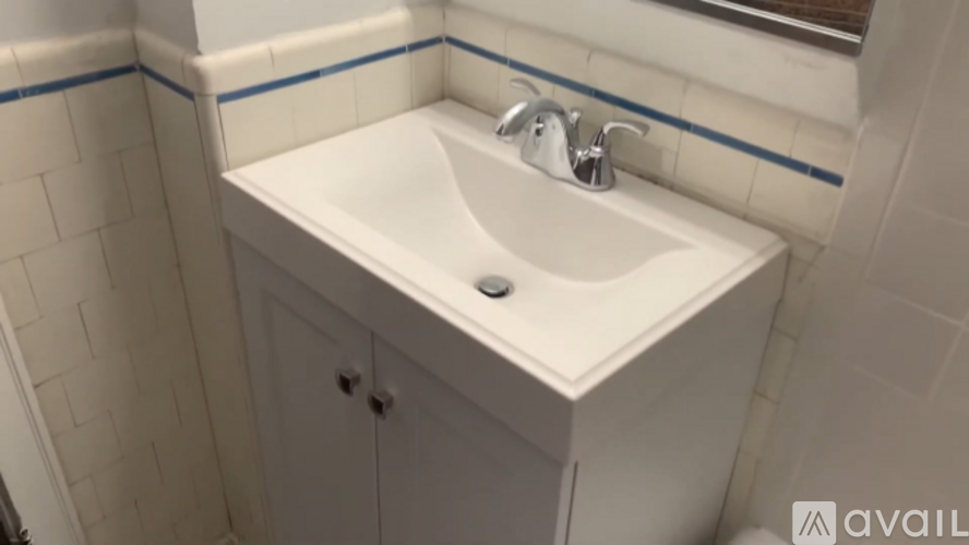 A white sink with a silver faucet in a bathroom.