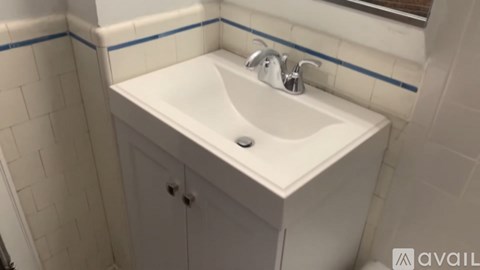 A white sink with a silver faucet in a bathroom.