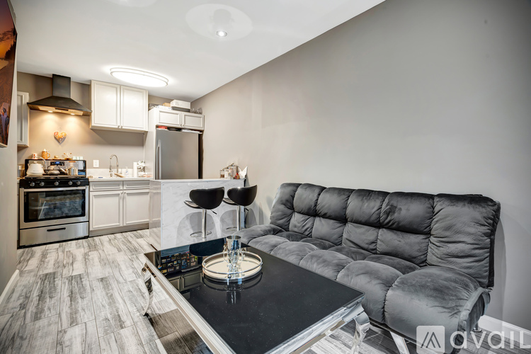 A modern kitchen with a grey sofa and a black table.