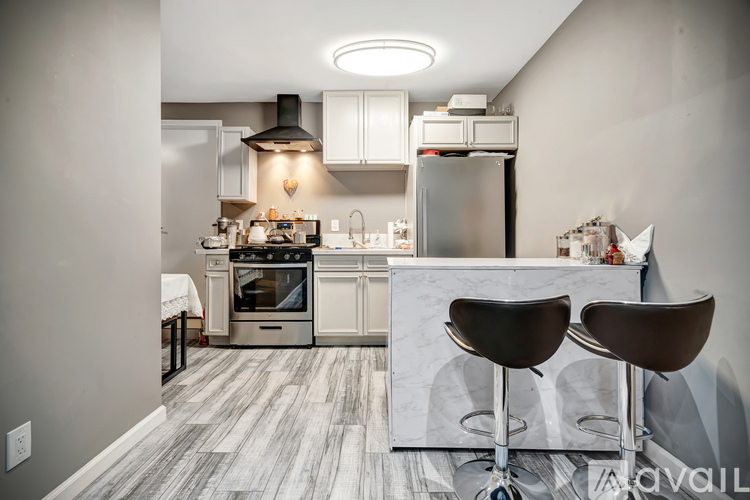 A modern kitchen with a bar stool in front of the island.