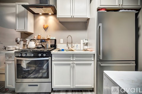 A kitchen with a stove top oven and a refrigerator.