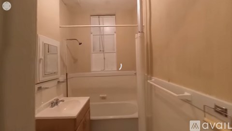 A bathroom with a tub, sink, and shower.