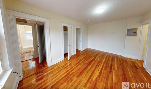 A room with wooden flooring and white walls.