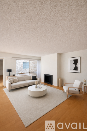 A living room with a white couch, a white coffee table, and a white chair.