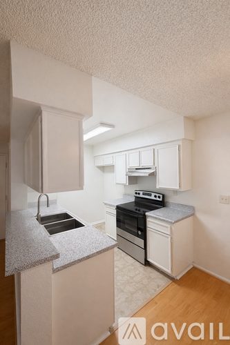 A kitchen with white cabinets and a granite countertop.