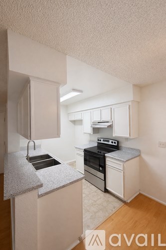 A kitchen with white cabinets and a granite countertop.