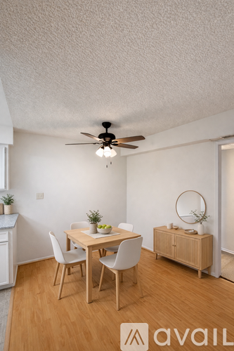 A room with a table, chairs, and a ceiling fan.