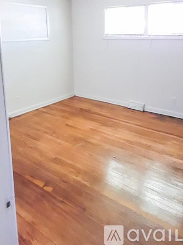 A room with wooden flooring and white walls.