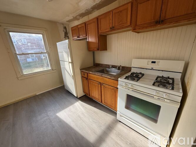 A kitchen with white cabinets and a tiled floor.