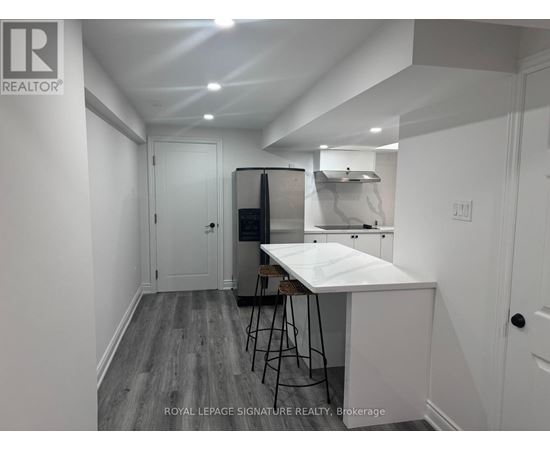 A white kitchen with a table and chairs in a room with white walls.