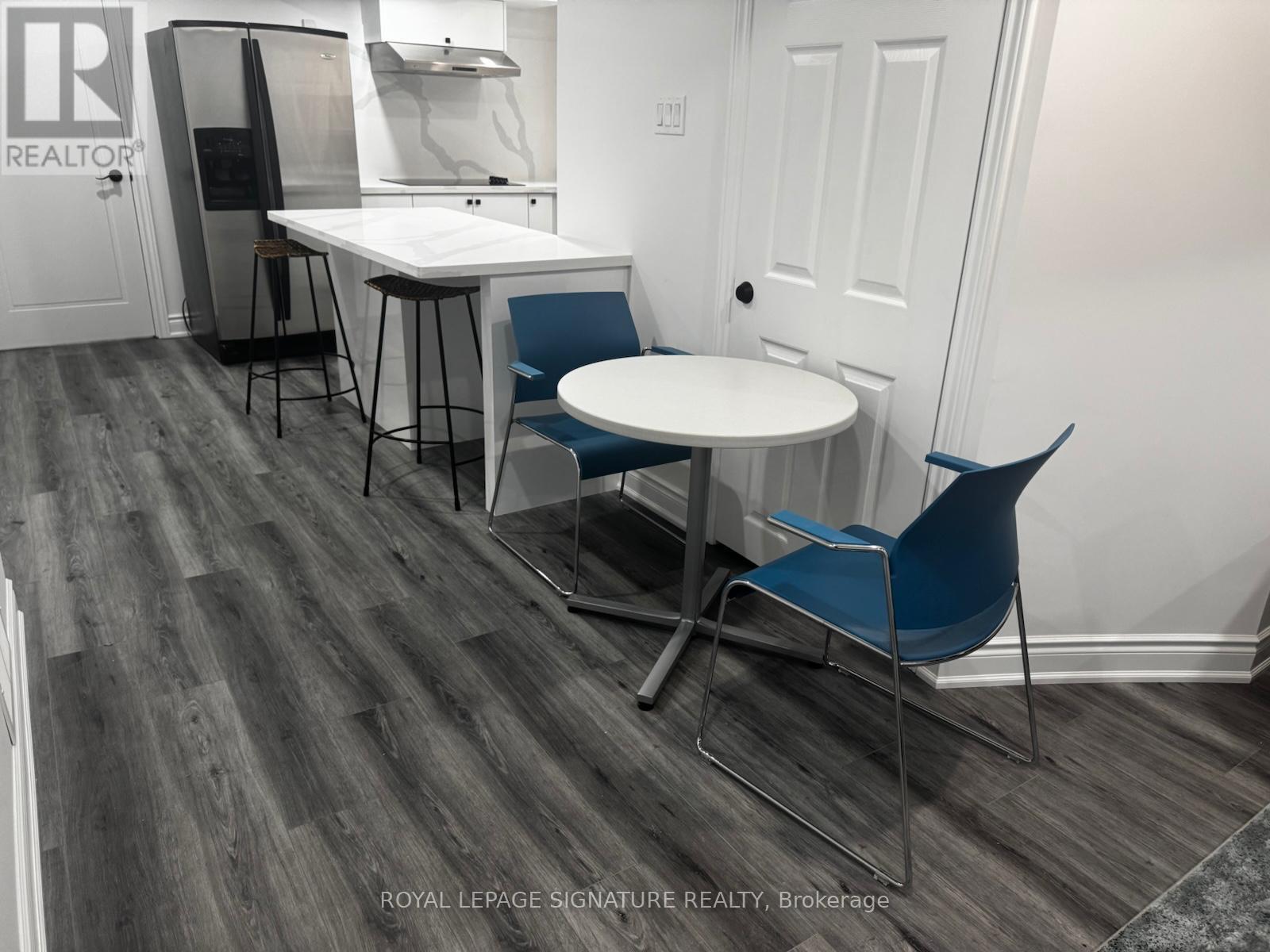 A dining area with a white table and blue chairs.
