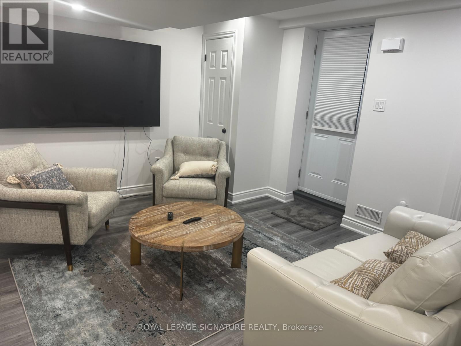 A living room with a flat screen TV mounted on the wall.