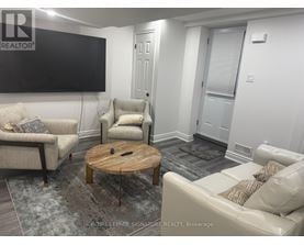 A living room with a flat screen TV mounted on the wall.