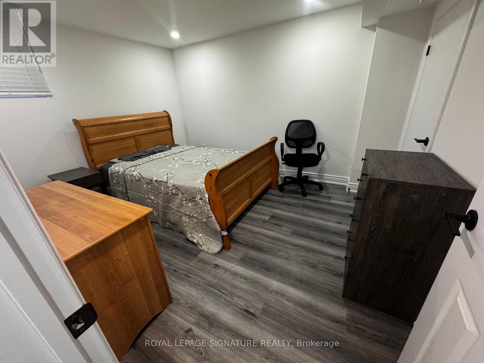 A bedroom with a bed, desk, and chair.