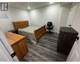 A bedroom with a bed, desk, and chair.