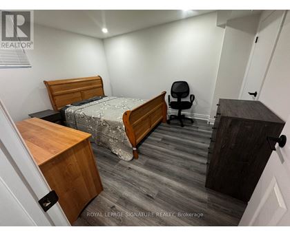 A bedroom with a bed, desk, and chair.