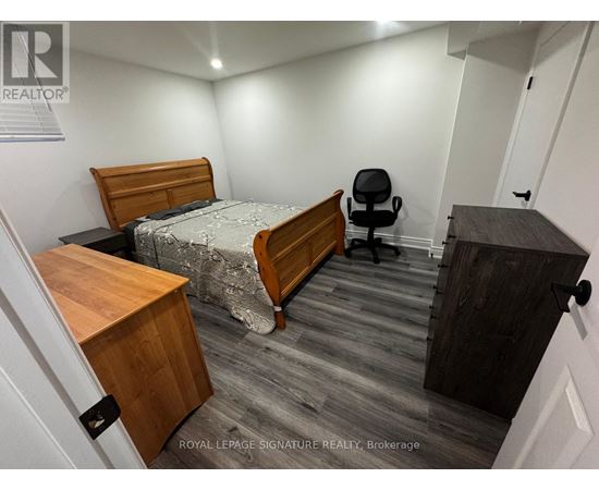 A bedroom with a bed, desk, and chair.