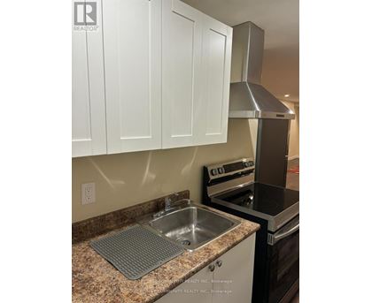 A kitchen with a stove, oven, and sink.