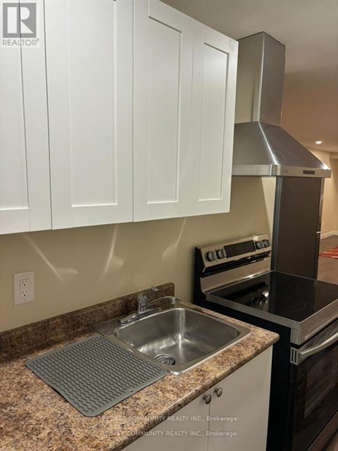 A kitchen with a stove, oven, and sink.