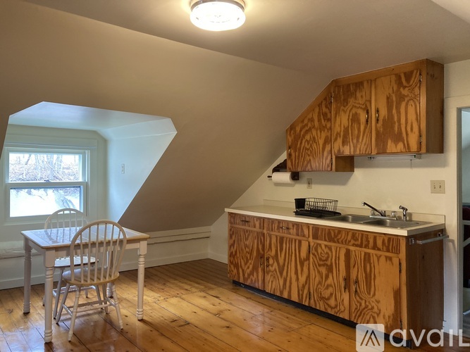 A kitchen with wooden cabinets and a white chair.