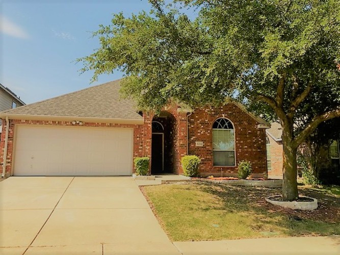 A house with a tree in front.