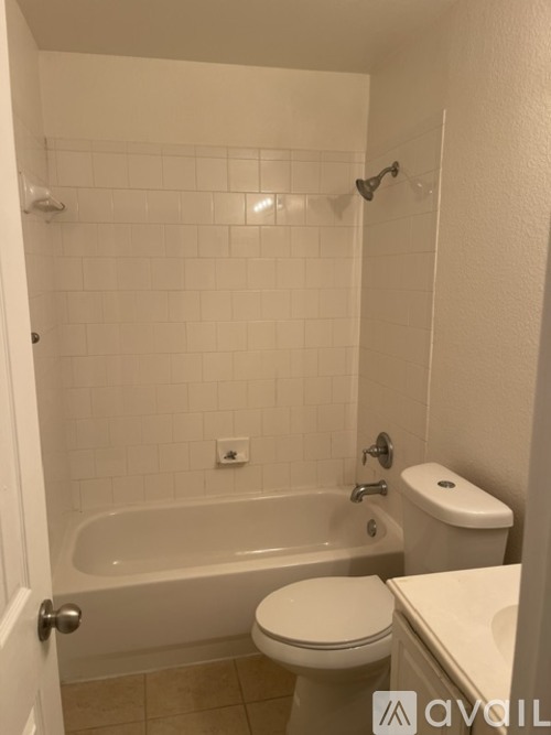 A white toilet is next to a bathtub in a bathroom.