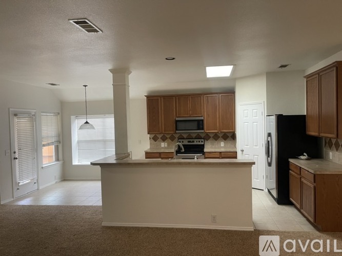 A kitchen with white walls and brown cabinets.