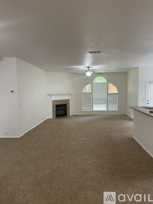 A spacious living room with a fireplace and large windows.